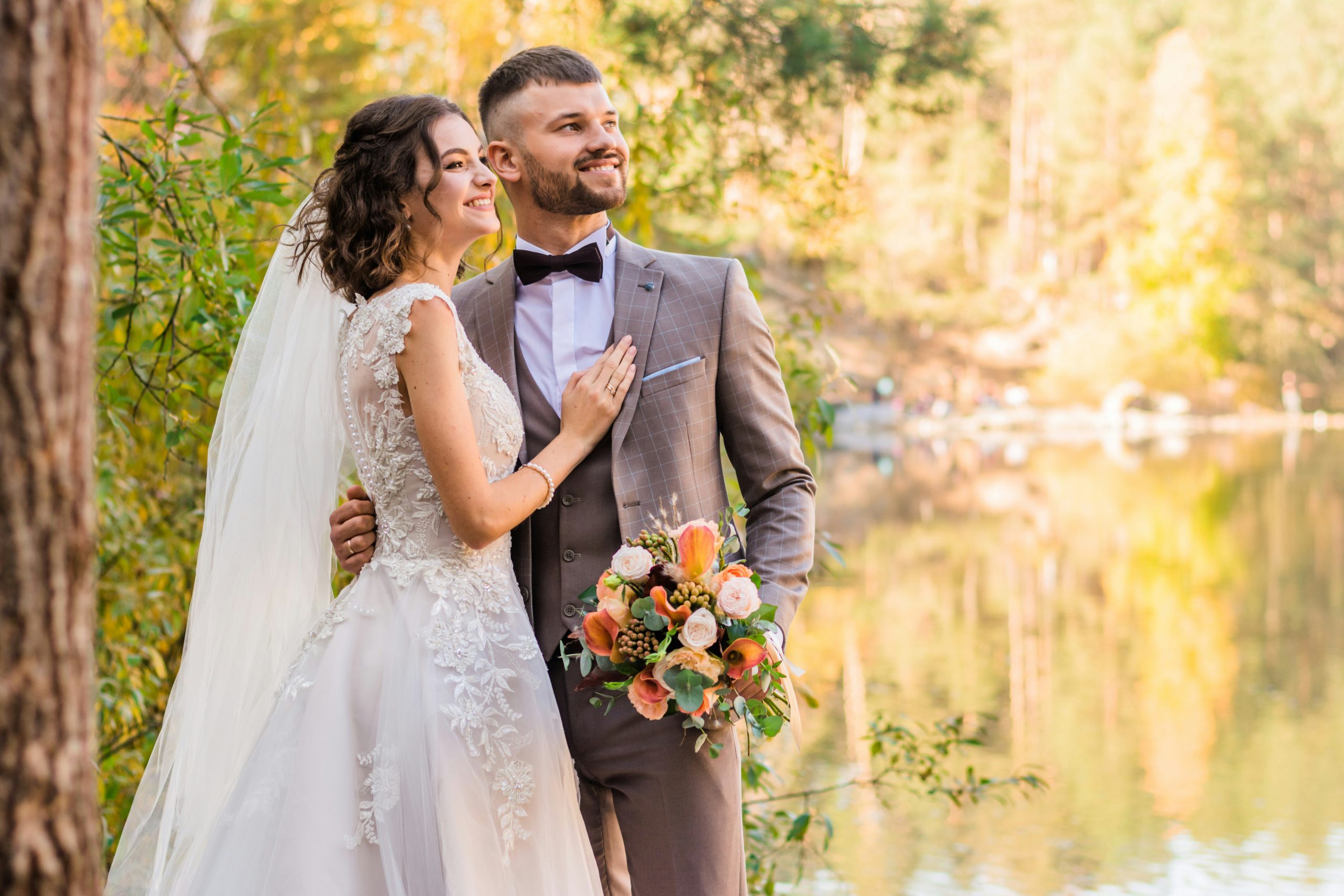 Groom and bride posing by water lake