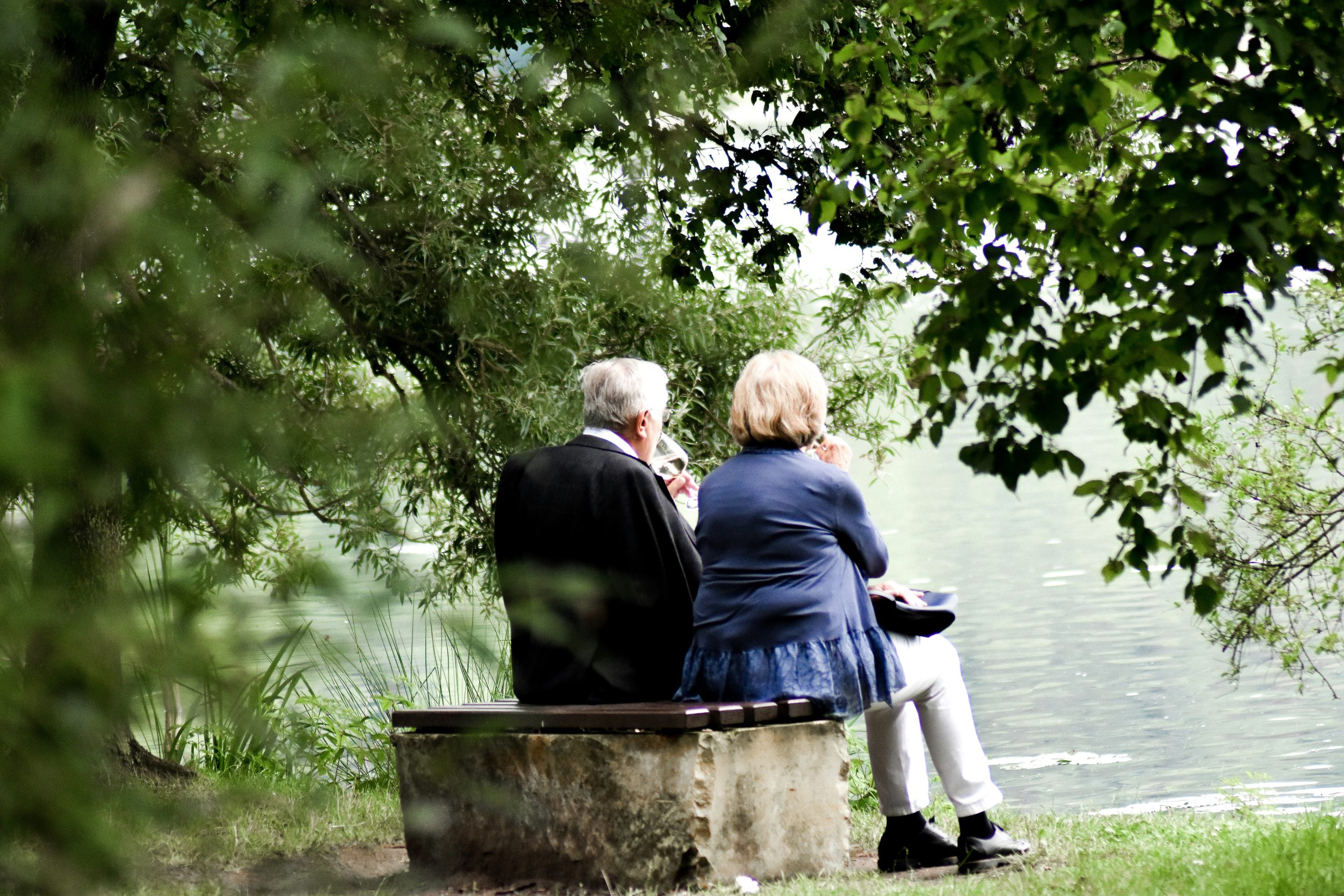 older couple sitting by river