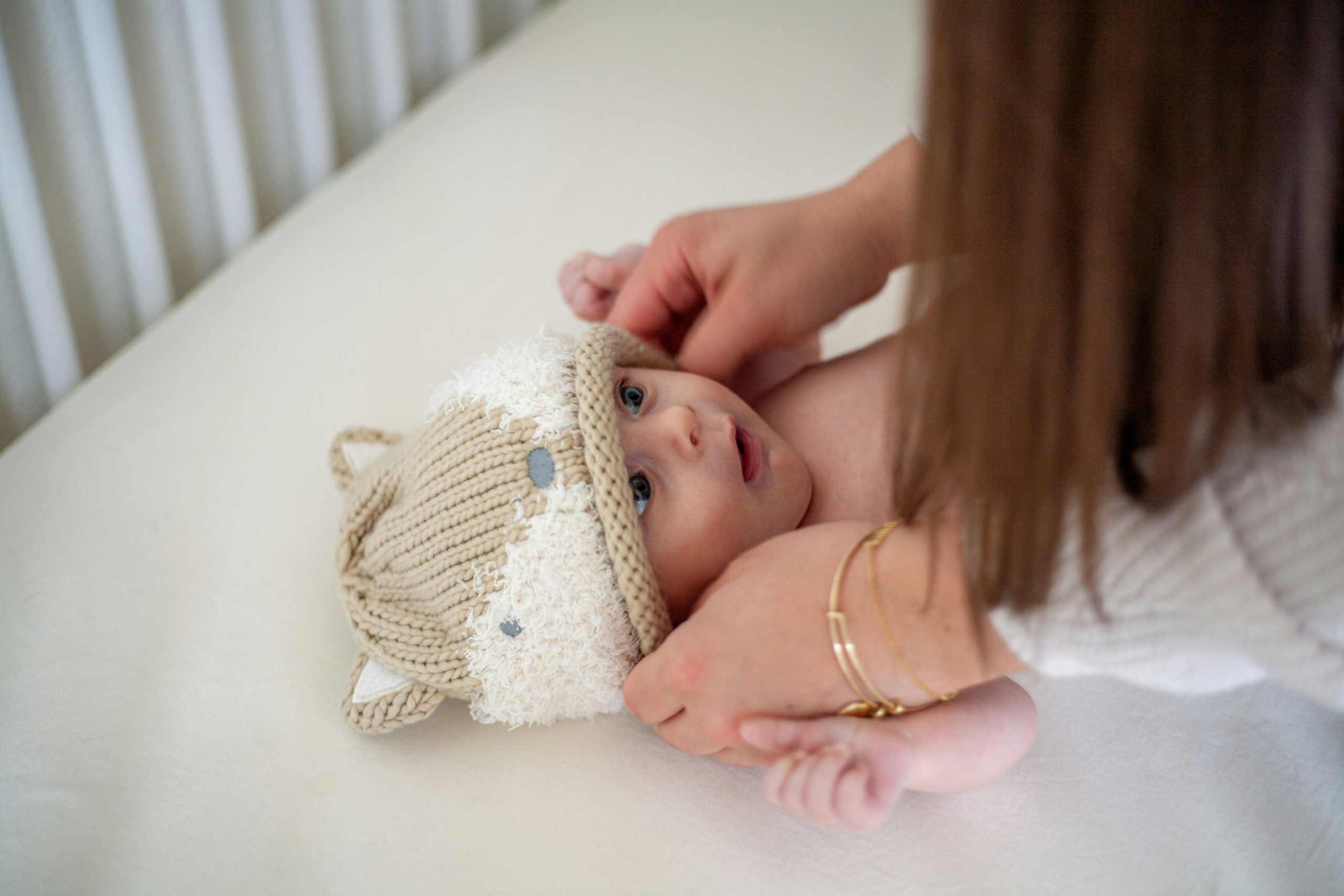 mother putting beanie on baby